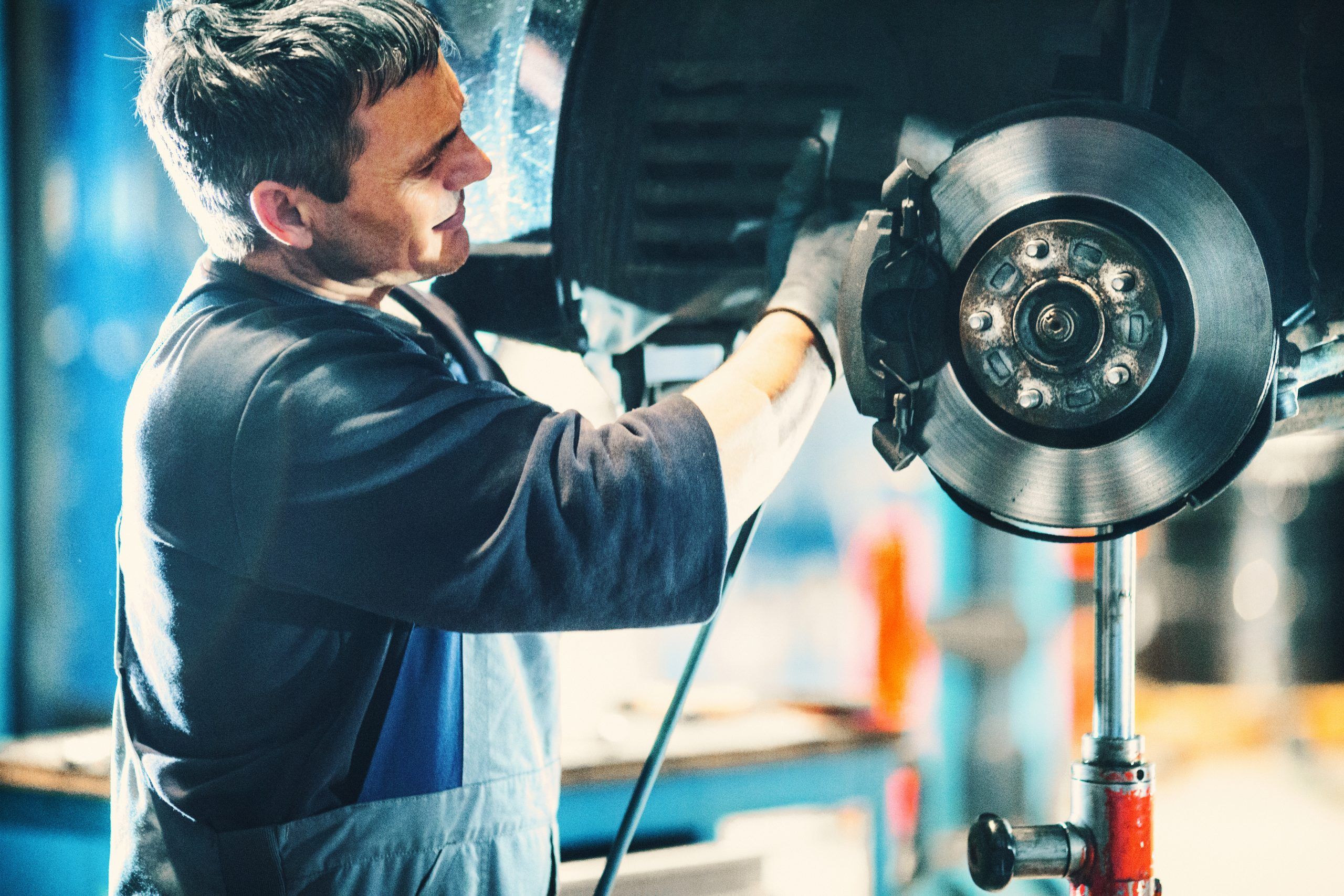 Monteur werkt aan de remschijf van een auto